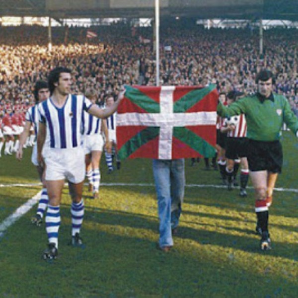 Los equipos saltan al campo en el derby vasco, el 5-XII-1976, portando la ikurriña.